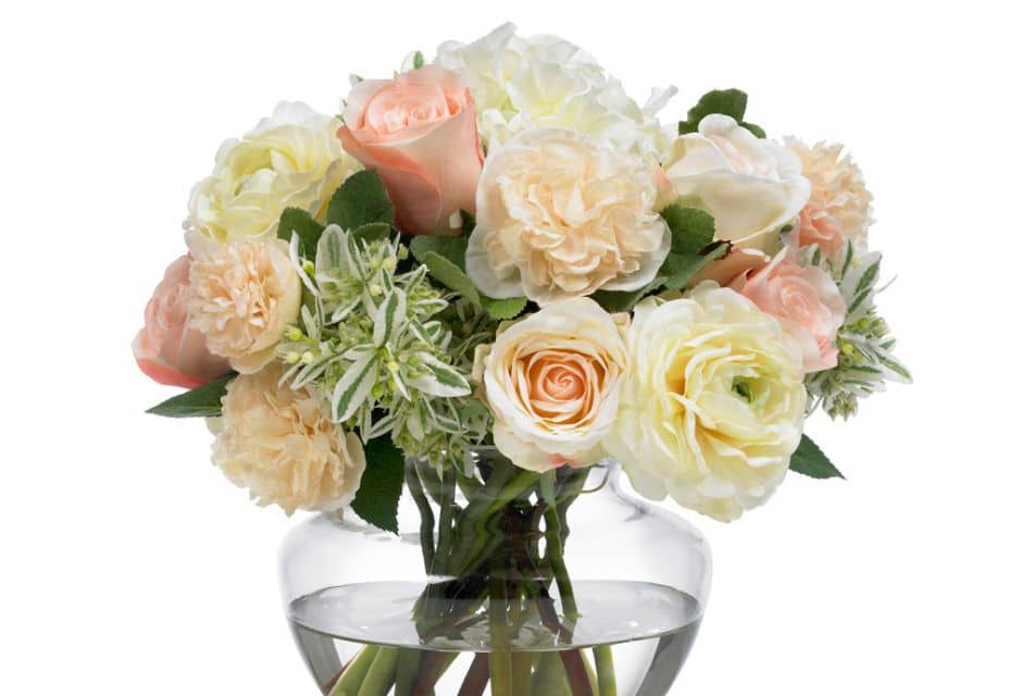 Glass vase holding a bouquet of white, ivory and blush flowers