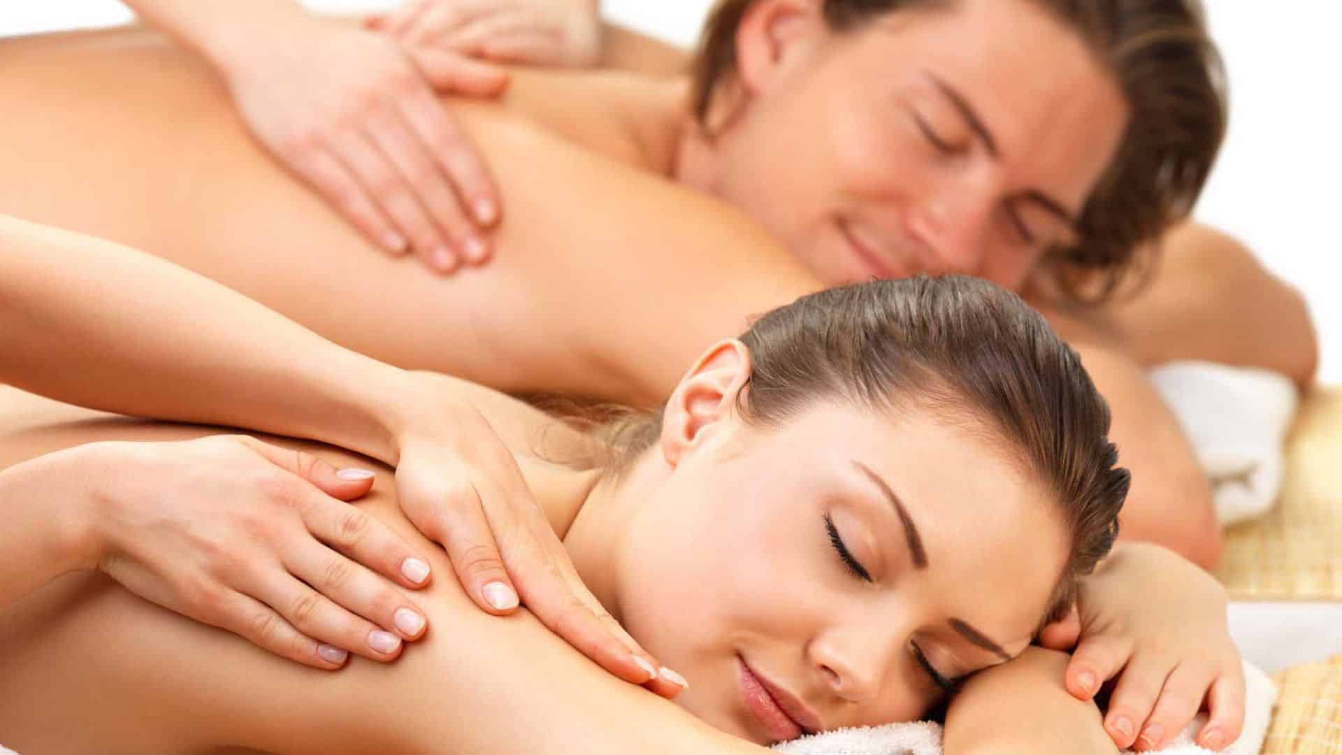 A man and woman lying on their stomachs getting a couples massage